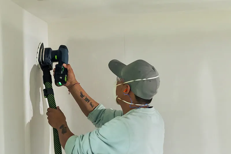 Tradesman sanding wall