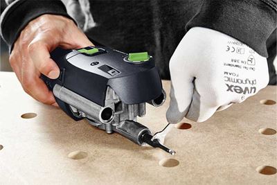 A tradesperson detaches a router bit from a machine