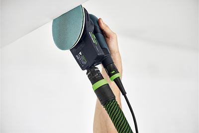 A corner is sanded with a sander and an abrasive net