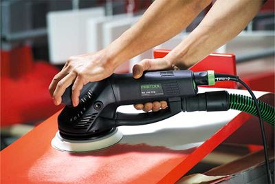 A red surface is worked on with a Rotex sander