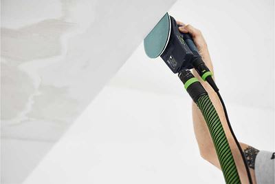 A Festool sander with a sanding pad in operation